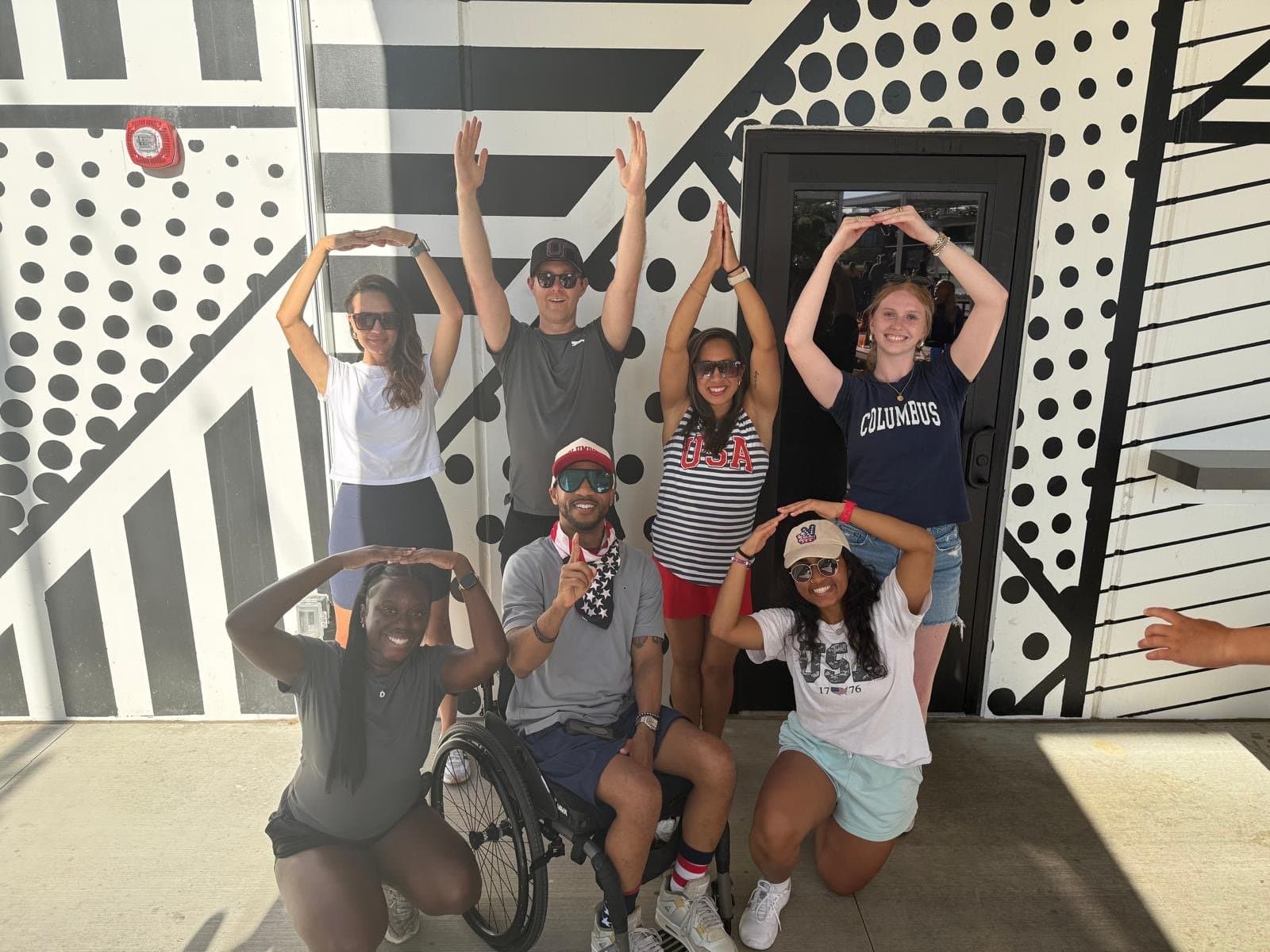 PRO-SCI team members posing together outdoors in front of a mural